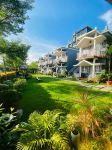a row of apartment buildings with a green yard at The Cristallo Resort in Shānti Niketan
