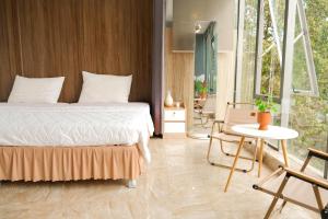 a bedroom with a bed and a table and chairs at Sunny 1 Hometel Vinh Long in Vĩnh Long
