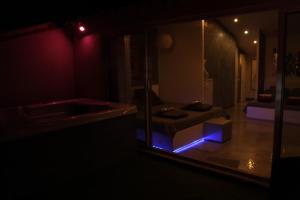 サン・レミ・ド・プロヴァンスにあるLes Suites de Naevagのソファと鏡付きの部屋が備わる暗い部屋