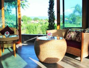 a living room with rattan furniture and a table at Family House Zen Boutique Resort in Pai