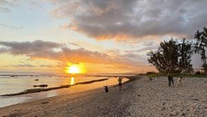 a group of people standing on a beach at sunset at Zébulon in Saint-Pierre