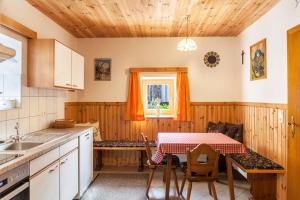 eine Küche mit einem Tisch und einem Tisch und Stühlen in der Unterkunft Neuhaus Alm in Gerlosberg
