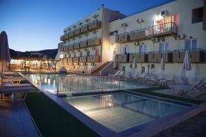 a hotel with a swimming pool in front of a building at Hotel Athinoula in Kefalos