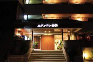 um edifício com escadas e uma porta vermelha à noite em Hotel Luandon Shirahama em Shirahama