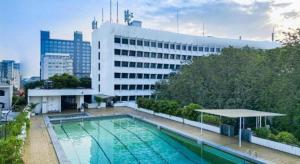 a large swimming pool in front of a building at Elmi Hotel in Surabaya