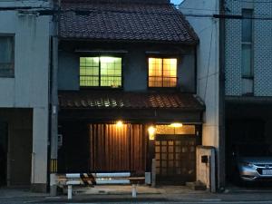 a house with two windows and a gate on a street at Guesthouse Kiten in Gifu