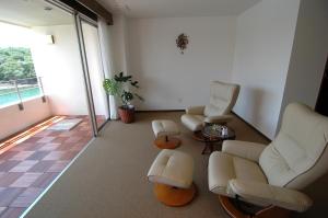 a living room with two chairs and a table at Hotel Luandon Shirahama in Shirahama