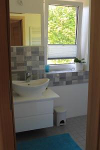 baño con lavabo y ventana en Apartamentai Tarp trijų ežerų en Tytuvėnai