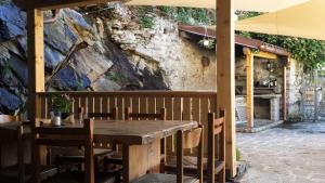 uma mesa de madeira e cadeiras em frente a uma parede de pedra em Appartamento Le Chalet em Albosaggia