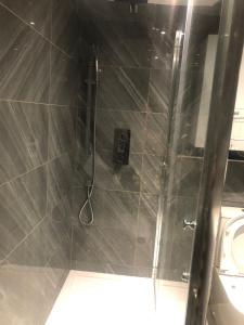 a shower with a glass door next to a toilet at 96TR Double bed bedroom - Edmonton green in Edmonton