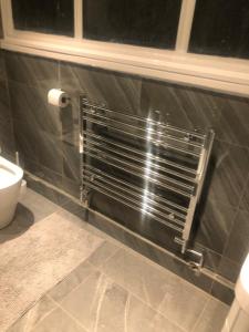 a bathroom with a metal radiator on the wall at 96TR Double bed bedroom - Edmonton green in Edmonton