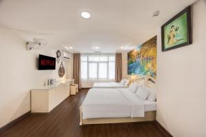 a white bedroom with two beds and a desk at A25 Hotel - 22 Nguyễn Cư Trinh in Ho Chi Minh City +29 photos