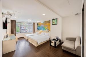 a bedroom with a white bed and a couch at A25 Hotel - 22 Nguyễn Cư Trinh in Ho Chi Minh City