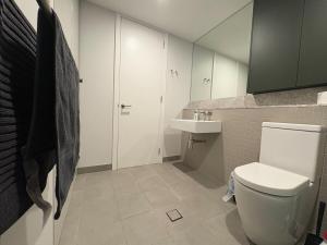 a bathroom with a white toilet and a sink at Canberra CBD modern new 2B apartment free Parking in Canberra +14 photos