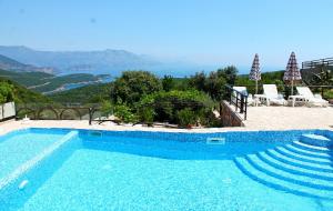 uma piscina azul com vista para as montanhas em Apartments Villa Milna 1 em Budva