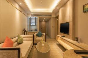 a living room with a couch and a tv at Dezhou Regal Kangbo Hotel in Dezhou