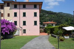 a pink building with a hill in the background at Bouganville in Seravezza