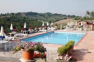 a beach with a pool, chairs, and tables at La Loggia - Villa Gloria -Adults Only in Quercegrossa