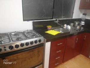a kitchen with a stove and a sink at El departamento de Lucho en El Valle in Loja +4 photos
