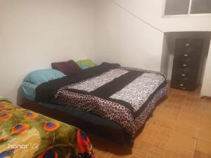 a bedroom with a bed and a dresser at El departamento de Lucho en El Valle in Loja