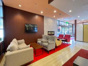 a living room with a couch and chairs and a tv at Rembrandt Inn Kazusa in Kimitsu