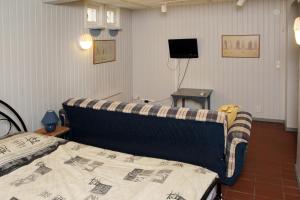 Vuohensaari Camping في سالو: غرفة نوم بسرير واريكة في غرفة