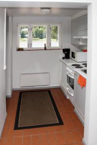 a kitchen with white cabinets and a stove top oven at Vuohensaari Camping in Salo