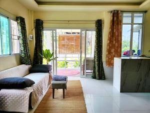 ein Wohnzimmer mit einer Couch und einigen Fenstern in der Unterkunft Kopan House View point in Thongsala