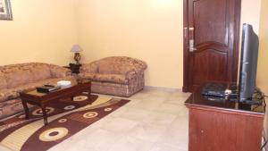 a living room with a couch and a tv at ضيافة بيت المسرة للشقق المخدومة in Al Khobar