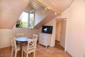 a dining room with a table and a tv at Nid douillet vaudois avec mezzanine in Bussigny