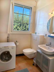 a bathroom with a washing machine and a sink at Nid douillet vaudois avec mezzanine in Bussigny