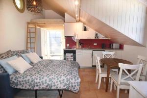 a bedroom with a bed and a table and a kitchen at Nid douillet vaudois avec mezzanine in Bussigny +7 photos