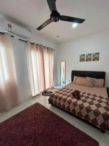 a bedroom with a bed and a ceiling fan at MH meru homestay in Chemor