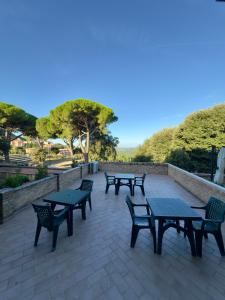 una fila di tavoli e sedie su un patio di La Dimora Di Roberta a Montalcino