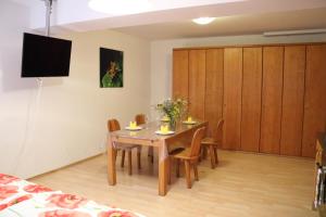 a dining room with a table and chairs and a tv at Großzügige Souterrainzimmer in Munich