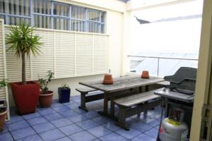a patio with a picnic table and a grill at Archies Bunker Affordable Accommodation in Napier
