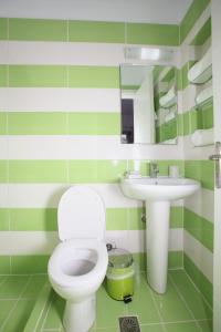 ネオ・キリマにあるSklavos Studiosの緑と白のバスルーム(トイレ、洗面台付)