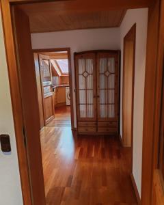 a hallway with two doors and a room with wooden floors at Ferienwohnung Mei Ruh' in Burggen
