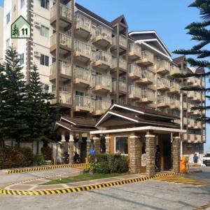 un gran edificio de apartamentos con un aparcamiento enfrente en 2 BR Affordable Condo Unit for Transient with perfect Pines View by 11 PinesView, en Baguio 4 fotos más