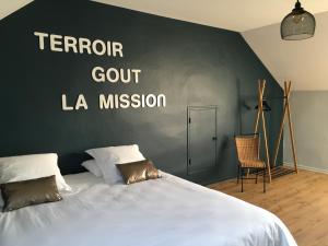 sypialnia z łóżkiem ze ścianą ze słowami terror court la mission w obiekcie La Maison du Clos du Roi w mieście Mercurey