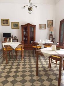 - une salle à manger avec des tables et des chaises sur un sol en damier dans l'établissement B&B Liberty, à Nardò