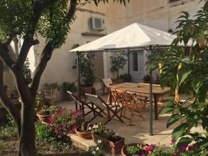 - une table et des chaises sous un parasol dans le jardin dans l'établissement B&B Liberty, à Nardò