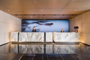 two men standing in front of a screen in a building at Shanghai Yunhe Yebo Hotel, Wuning Road Global Harbor Branch in Shanghai
