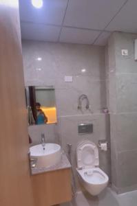 a bathroom with a white toilet and a sink at Premium stay in Greater Noida