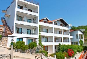 un edificio blanco con ventanas azules en Apartments Villa Milna 1, en Budva