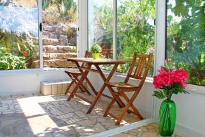 a table and chairs in front of a window at Apartments Villa Milna 1 in Budva