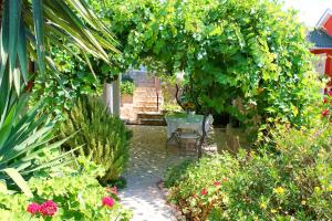 a garden with a table and a bunch of plants at Apartments Villa Milna 1 in Budva