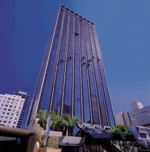 a tall building with a lot of windows at Executive Flat Campinas in Campinas