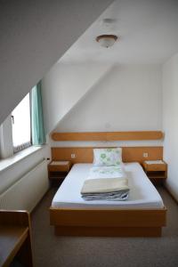 um pequeno quarto com uma cama num quarto em Kronenwirt em Gurk