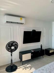 a living room with a flat screen tv and a fan at leslies apartamentos in Cartagena de Indias